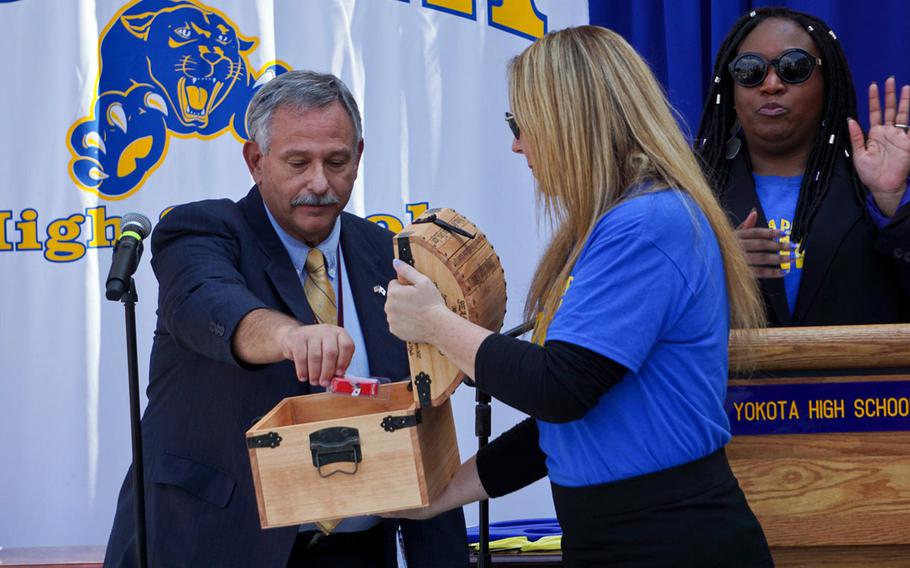 Steven Bloom, superintendent of DODEA's Pacific East school district, places an item inside a time capsule during the ribbon-cutting ceremony for Yokota Air Base's new high school, Monday, Sept. 25, 2017.