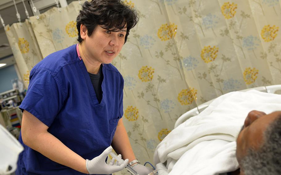 Lt. Liezl Dagum, a nurse at Naval Hospital Jacksonville's intensive care unit, performs a saline flush of a patient's intravenous line on Aug. 26, 2016.