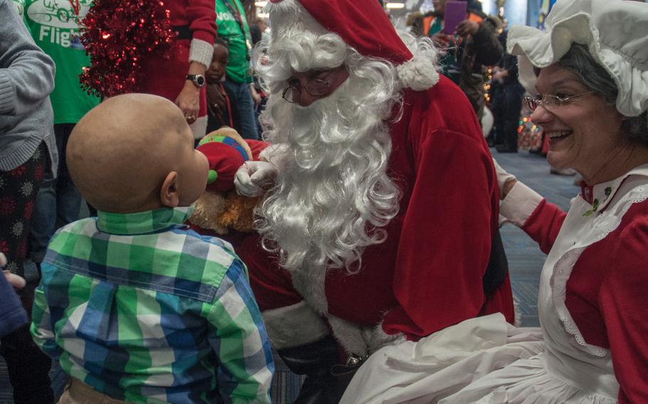 Mr. and Mrs. Santa Claus greet children's hospital patient Abdulah Iftikhar, 7, a passenger from United Airlines' Fantasy Flight, which landed at the "North Pole" at Washington-Dulles International Airport in Virginia on Saturday, Dec. 9, 2017.