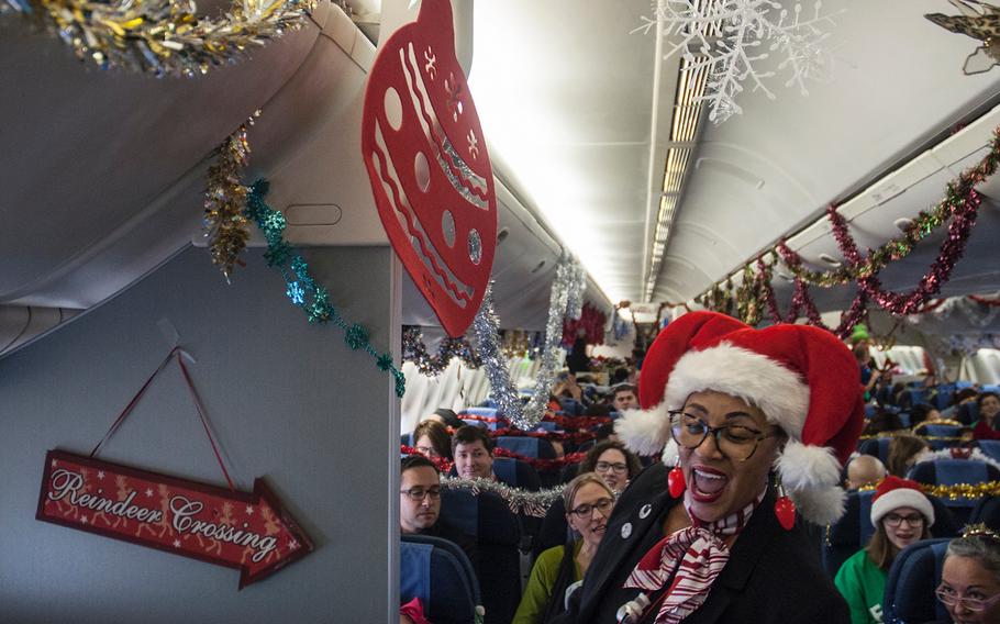 Teresa Little, a United Airlines flight attendant and self-proclaimed "Santa's Helper," dashes through the cabin as she leads Fantasy Flight passengers in a spirited sing-a-long of "Jingle Bells" prior to takeoff at Washington-Dulles International Airport in Virginia on Saturday, Dec. 9, 2017.
