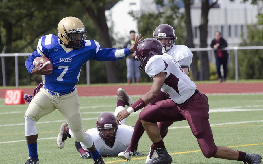 Wiesbaden junior quarterback Josh Blake holds off a Vilseck defender in their season-opening matchup Sept. 9, 2017 in Wiesbaden, Germany. Blake threw for two touchdowns and ran for another as the Warriors defeated the Falcons 38-0.