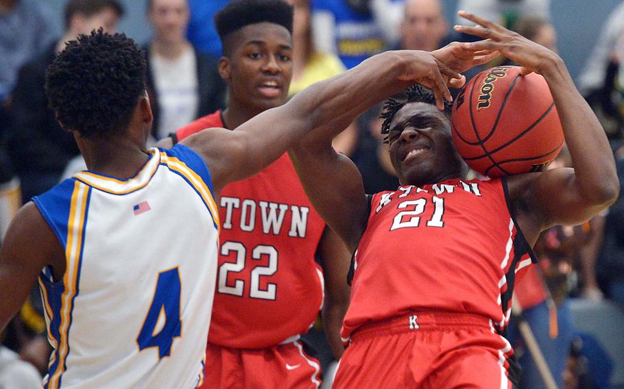 Wiesbaden's David Williams gets a hand in Kaiserslautern's Steve Segning's face as they fight for a rebound in Wiesbaden's 47-37 win in opening-day Division I action at the DODEA-Europe basketball championships in Wiesbaden, Germany, Wednesday, Feb. 22, 2017. Watching the action is Marlon Robbins.
                