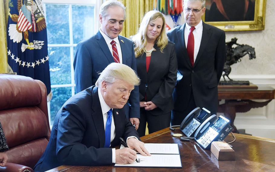 President Donald Trump signs an Executive Order on "Supporting our Veterans during their Transition from Uniformed Service to Civilian Life" on Tuesday, January 9, 2018 in the Oval Office of the White House in Washington, D.C.
