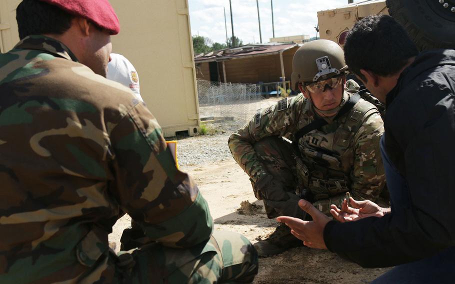 Capt. Christopher Hawkins, 1st Squadron, 38th Cavalry Regiment, 1st Security Force Assistance Brigade, middle, and an interpreter speaks with local national soldiers to gain information about a village during an enacted military operation on urban terrain event at Lee Field Oct. 23, 2017 at Fort Benning, Ga.
