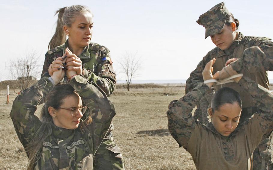 Women from the 26th Marine Expeditionary Unit and the Romanian army practice handling detainees on March 9, 2018 at the Capu Midia training area in Romania during the Spring Storm exercise.