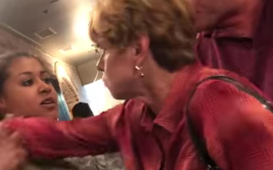 Judy Tucker is shown in a video attempting to reach past servicemember Stephanie Mitchell.