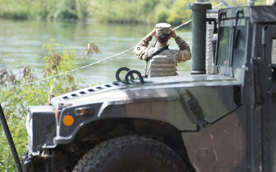 A soldier from the Texas National Guard scans the shores of the Rio Grande River in Starr County, Texas, April 10, 2018 as part of the federal call-up to the Texas-Mexico border.