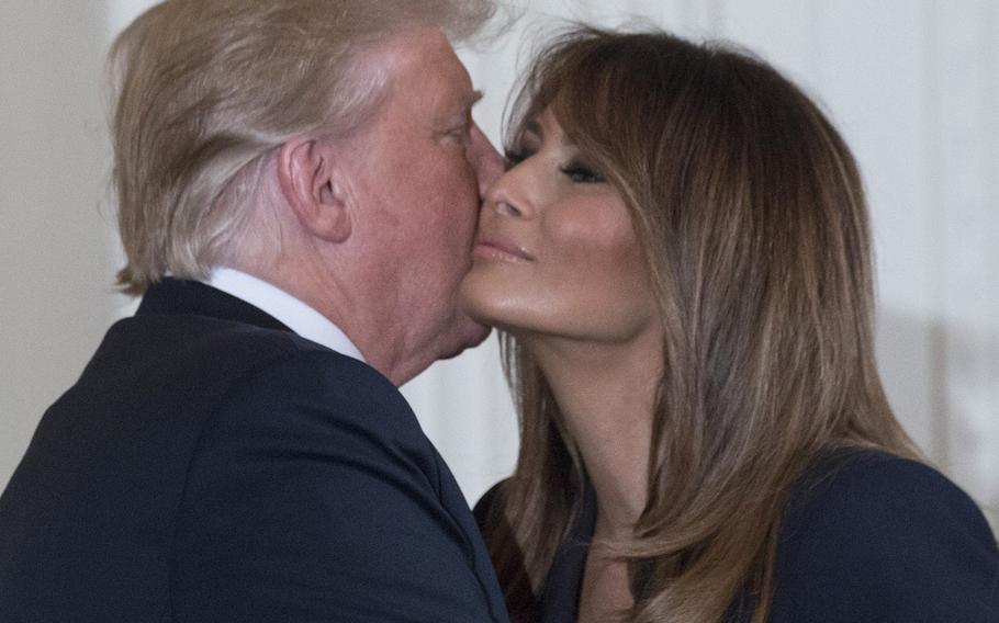 President Donald Trump gives wife Melania a kiss after the first lady spoke at a White House ceremony promoting employment for military spouses, May 9, 2018.