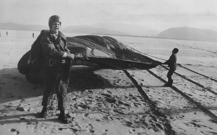 South Korean youth help Spc. David Darwin, 24, recover his parachute near the mouth of the Han River., Dec. 21, 1960.