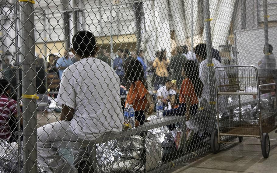 In this June 17, 2018 photo provided by U.S. Customs and Border Protection, people who have been taken into custody related to cases of illegal entry into the United States are shown at a facility in McAllen, Texas.