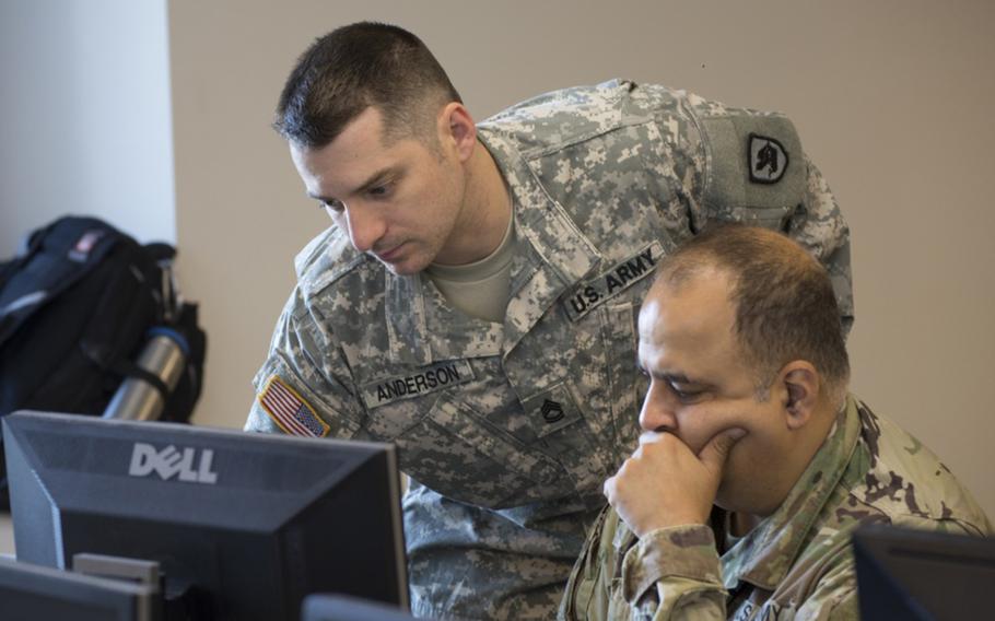 Sgt. 1st Class Samuel Anderson, with the Washington National Guard, advises Cpt. Sameer Puri, 56th Theater Information Operations Group, at Highline Community College in Des Moines, Wash., on July 6. 2018.