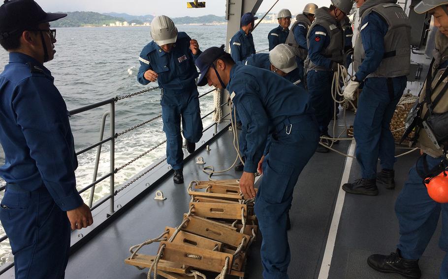 Members of the Japan Self-Defense Force prepare a ladder used to help a team lower in the water to investigate a nearby ship during Pacific Shield 2018 on July 25, 2018.