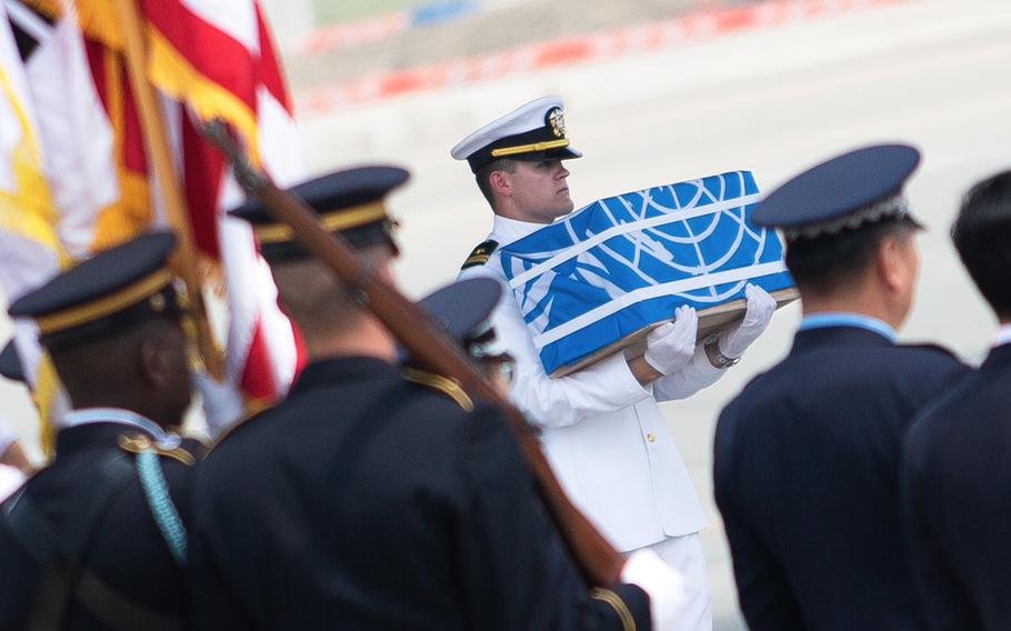 The first of 55 cases of remains repatriated from North Korea is carried off a plane at Osan Air Base, South Korea, Friday, July 27, 2018. 