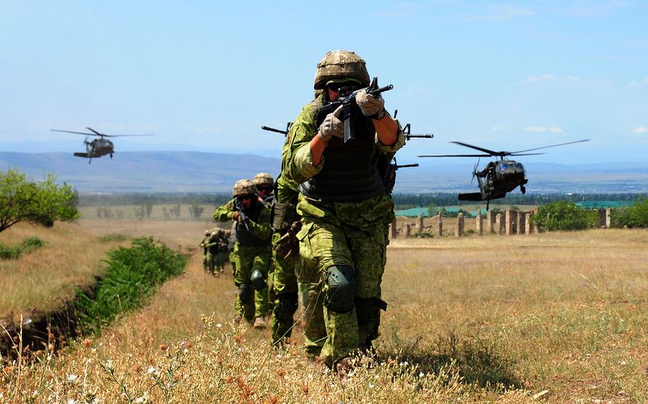 Ukrainian infantry marines advance after insertion by the Marietta-based Alpha Company, 171st Aviation Regiment, U.S. Army National Guard UH-60 Black Hawk helicopters during an combined urban operation exercise with Georgian special forces, U.S. soldiers and German forces as part of Noble Partner 18 at Vaziani Training Area, Georgia, Aug. 5, 2018. 