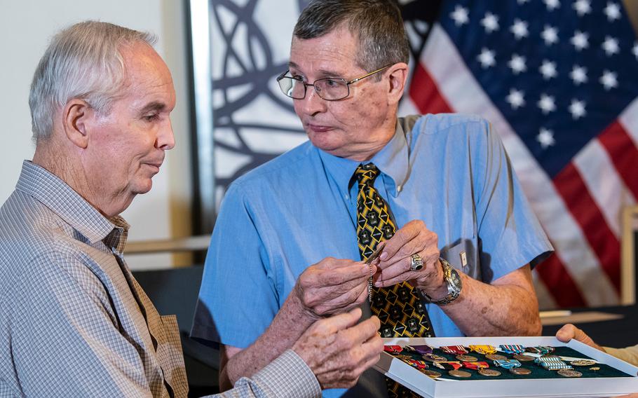 Charles McDaniel Jr. looks at his brother Larry while holding the dog tag that belonged to their father, Army Master Sgt. Charles H. McDaniel, who was listed as missing in action during the Korean War in 1950. The dog tag was among the 55 caskets of remains that North Korea handed over to the United States in July 2018. The box contains all the medals Master Sgt. McDaniel was awarded while he served in the Army, including a Purple Heart issued posthumously.
