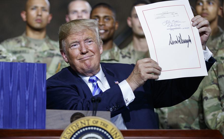 President Donald Trump smiles during a signing ceremony for a $716 billion defense policy bill named for Sen. John McCain, Monday, Aug. 13, 2018, in Fort Drum, N.Y.