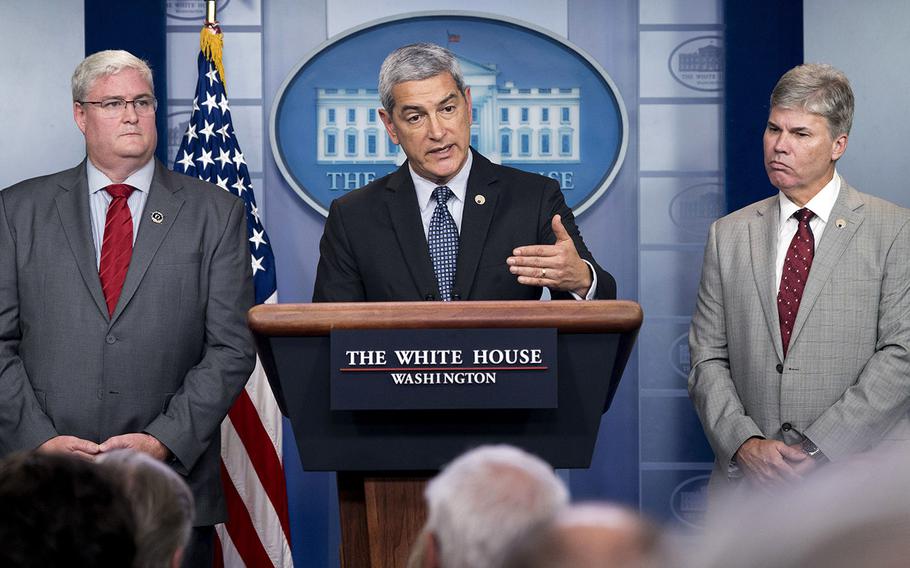 Kelly McKeague, director of the Defense POW/MIA Accounting Agency, center, accompanied by Timothy McMahon, director of Forensic Services at the Armed Forces Medical Examiner's DNA Identification Lab, left, and John Byrd of the Defense POW/MIA Accounting Agency's Central Identification Laboratory, right, speaks about the recently repatriated remains from North Korea during the daily press briefing at the White House, Tuesday, Aug. 14, 2018.