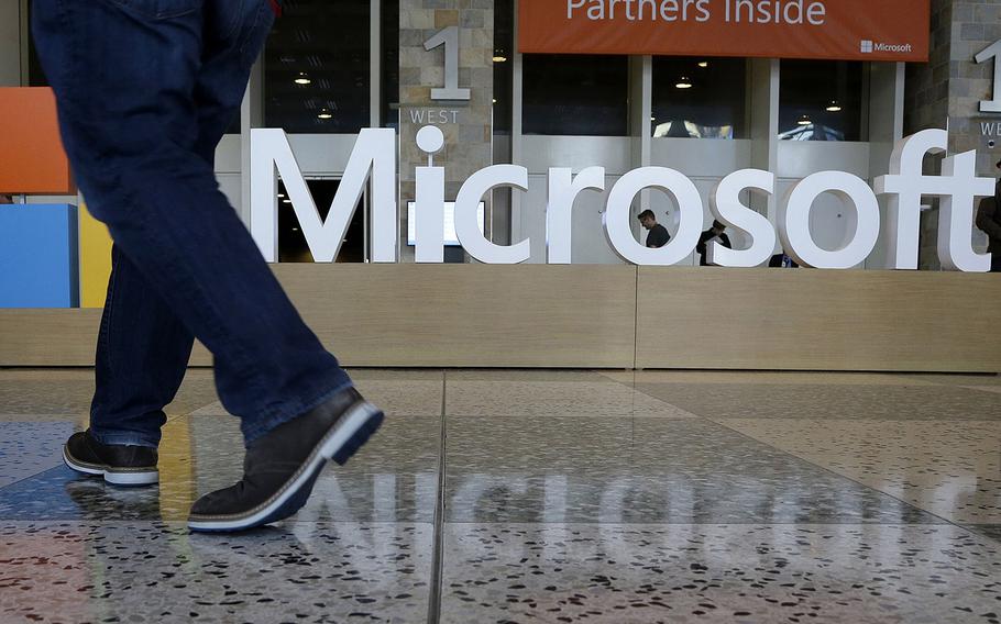 In this April 28, 2015, file photo, a man walks past a Microsoft sign set up for the Microsoft BUILD conference at Moscone Center in San Francisco. Microsoft has uncovered new hacking attempts by Russia targeting U.S. political groups ahead of the midterm elections. The company said Tuesday, Aug. 21, 2018, that a group tied to the Russian government created fake websites that appeared to spoof two American conservative organizations: the Hudson Institute and the International Republican Institute.