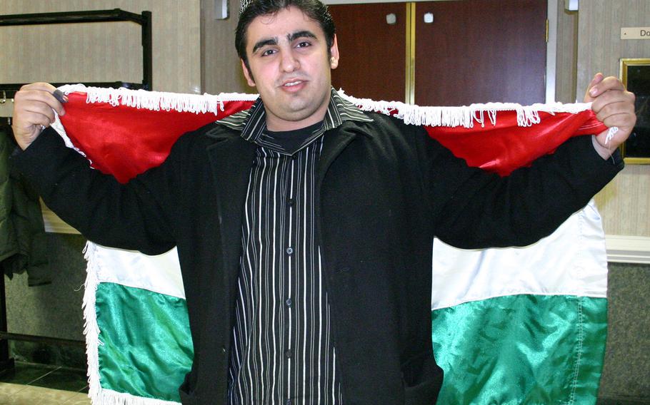Goran Rahim wears the flag of Kurdistan over his shoulders as he votes in the Iraqi election at McLean, Va., in 2005.