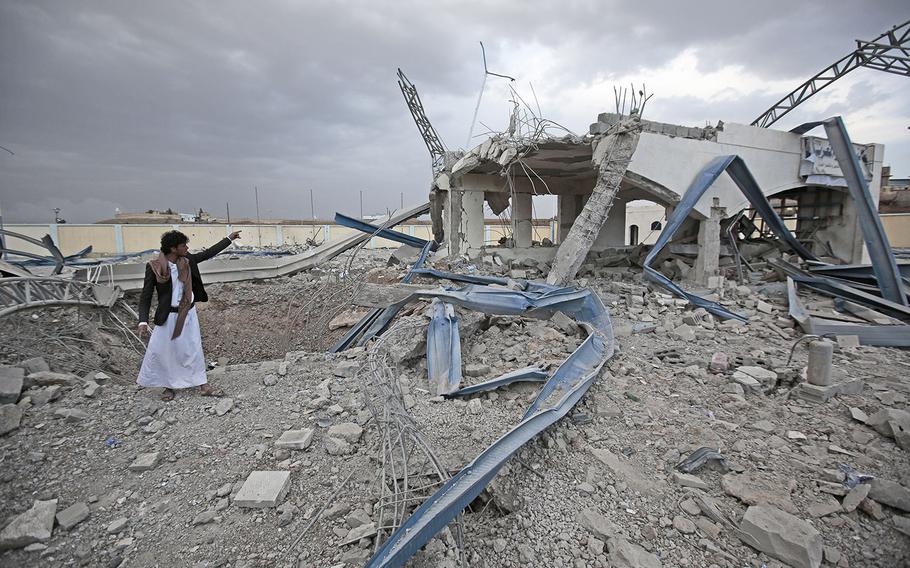 A Yemeni man inspects a destroyed petrol station after it was targeted by Saudi-led airstrikes on the outskirts of Sanaa in May 2018.