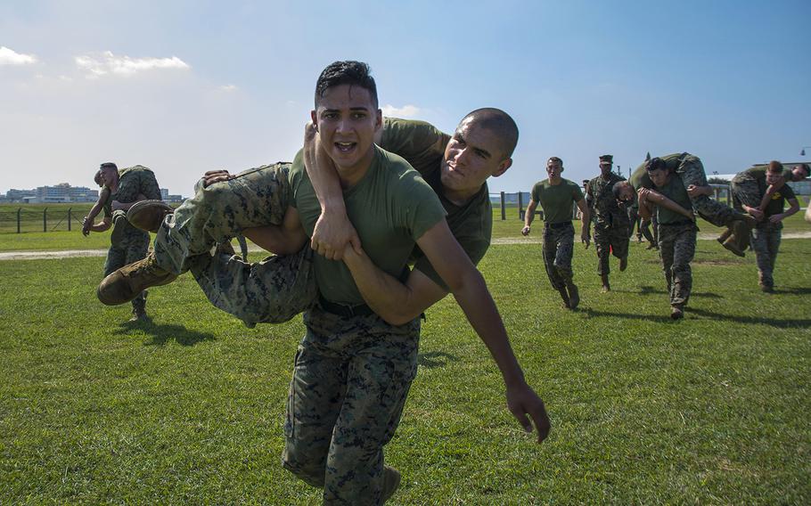 Marines perform fireman carries during a Warrior Games event at Marine Corps Air Station Futenma, Okinawa, Oct. 25, 2018.