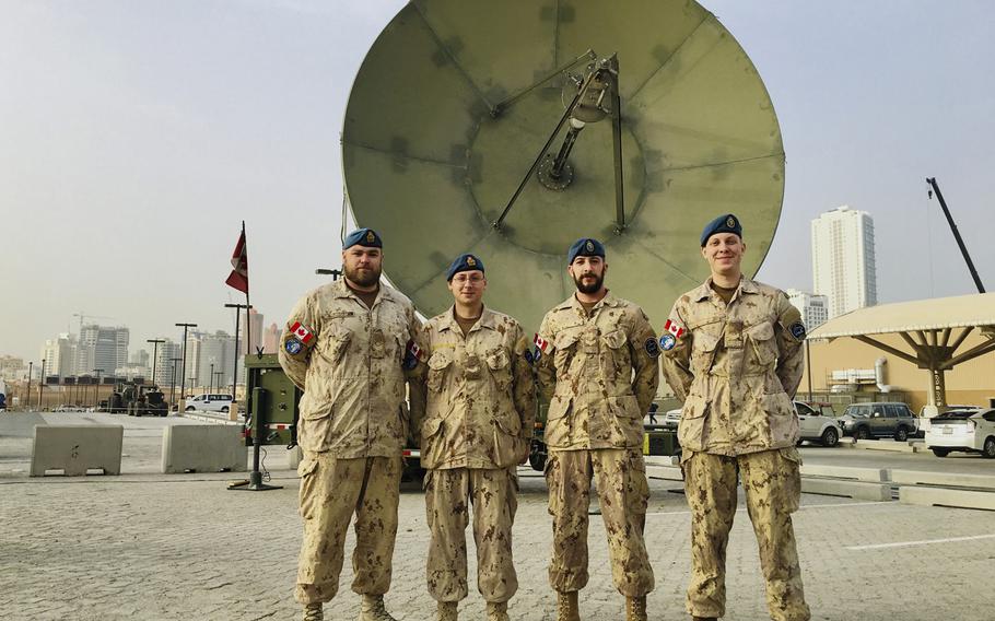 Combined Task Force 150 members Master Cpl. David Jackson, Cpl. Robert Pottage, Cpl. Marc Delaney and Cpl. Timothy Schultz stand in front of a satellite on Naval Support Activity Bahrain, January 23, 2019. The team made up of 30 Canadians and seven Australians work with 10 other Canadians running the Unclassified Remote-Sensing Situational Awareness satellite system. URSA monitors maritime traffic in the Persian Gulf and the historic narcotics ''smack track'' in the Arabian Sea and Indian Ocean.