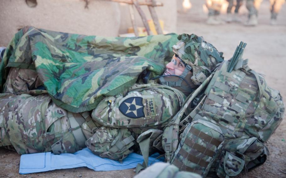 U.S. Army Capt. Kevin Wiley warms up with a poncho liner at Shele Kalay in Afghanistan, Jan. 16, 2012.