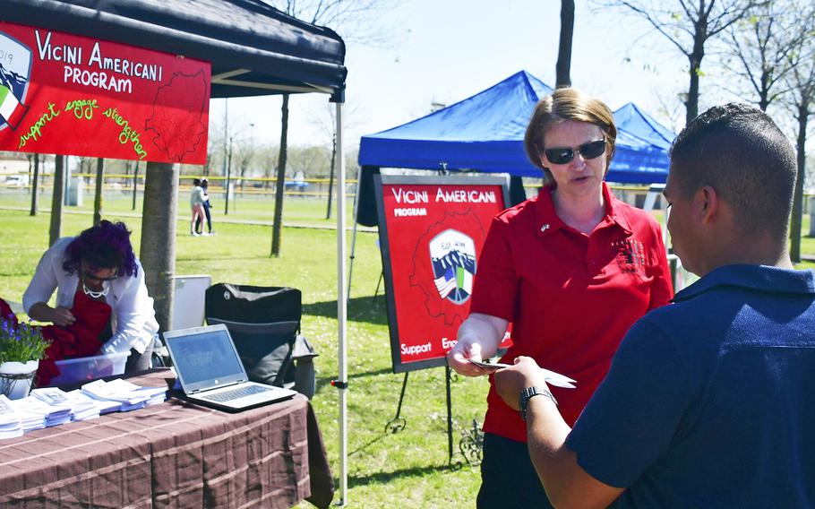 Master Sgt. Corina Cruceanu, one of the Vicini Americani program managers, speaks with a potential volunteer during the Spring Into Spring Festival at Aviano Air Base's Freedom Park, April 19, 2019. Some of the program's goals are to foster friendship and cooperation among Americans and Italians living as neighbors in the surrounding communities.