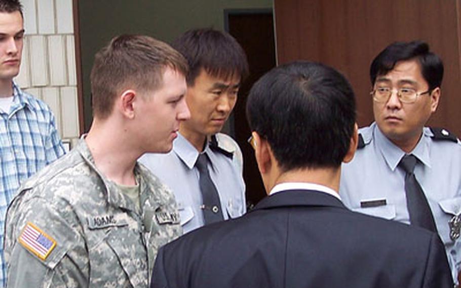 This June photo shows Pvt. Michael Curtis Adams, of the 55th Military Police Company, being led back to jail. Curtis received 3½ years in prison after being convicted of assaulting a taxi driver and stealing his cab.