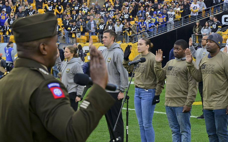 Lt. Gen. Bruce Crawford, the Army’s chief information officer, administers the oath of enlistment with more than 60 future soldiers, sailors and airmen during a mass joint-service swearing-in ceremony at Heinz Field in Pittsburgh on Nov. 10.