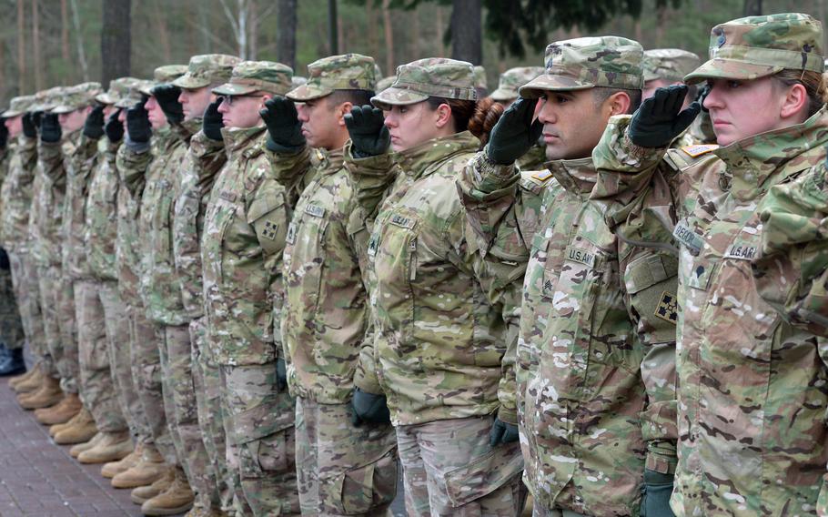 American rotational soldiers of the 4th Infantry Division salute during the national anthem at a welcoming ceremony for them in Zagan, Poland, in 2017.