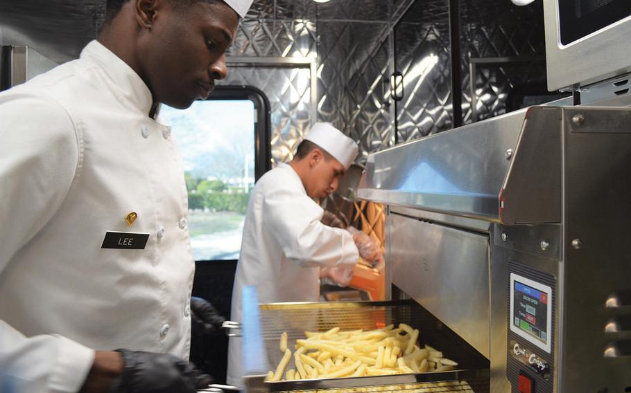 Spc. Isiah Lee checks on fries as they cook in an air fryer on the Culinary Outpost food truck Feb. 6, 2020, at Fort Hood, Texas. As part of the Army's initiative to offer soldiers healthier meal options, the food trucks do not have traditional grease fryers. 
