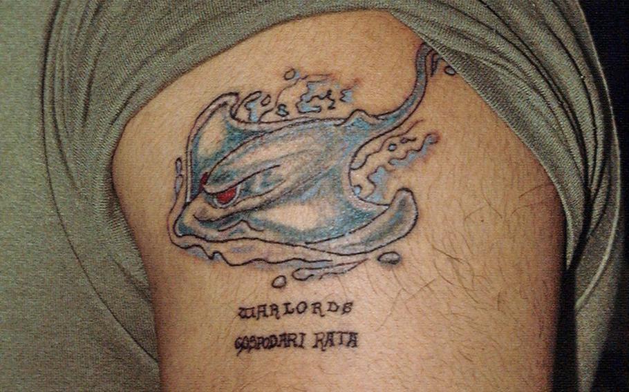 U.S. Marine Cpl. Richard Sierra shows off his tattoo, which has “Masters of War” written in Croatian.