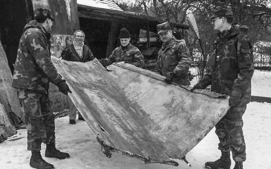 At Bad Muskau, Germany, in April, 1996, World War II pilot Dale Thornton, second from left, and airmen from Spangdahlem Air Base cart part of the tail section of Thornton's aircraft that was shot down at the end of the war to a nearby truck.