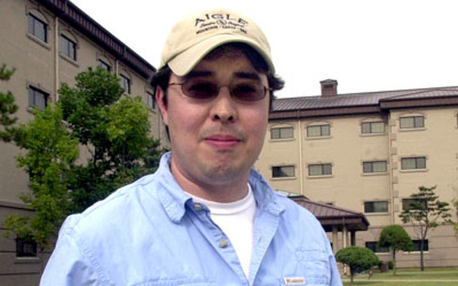 Scott Blair, a former soldier and spouse of a servicemember from Osan Air Base, holds a picture of his father, William Blair, and a Kurdish official taken when William Blair was stationed in Iraq with the Defense Intelligence Agency. William Blair later died from illnesses brought on by post-traumatic stress disorder.