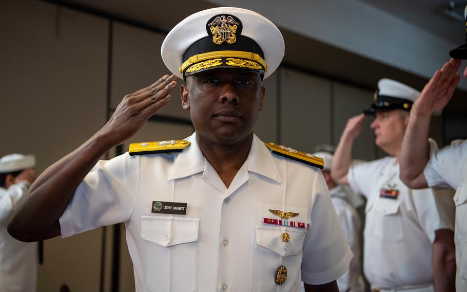 Rear Adm. Stephen Barnett renders a salute as he walks through sideboys during a change of command ceremony at Naval Base Kitsap-Bangor June 18, 2021. 
