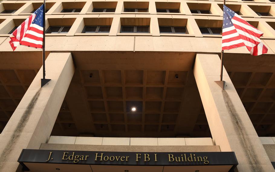 Two flags fly on the front of the FBI building.