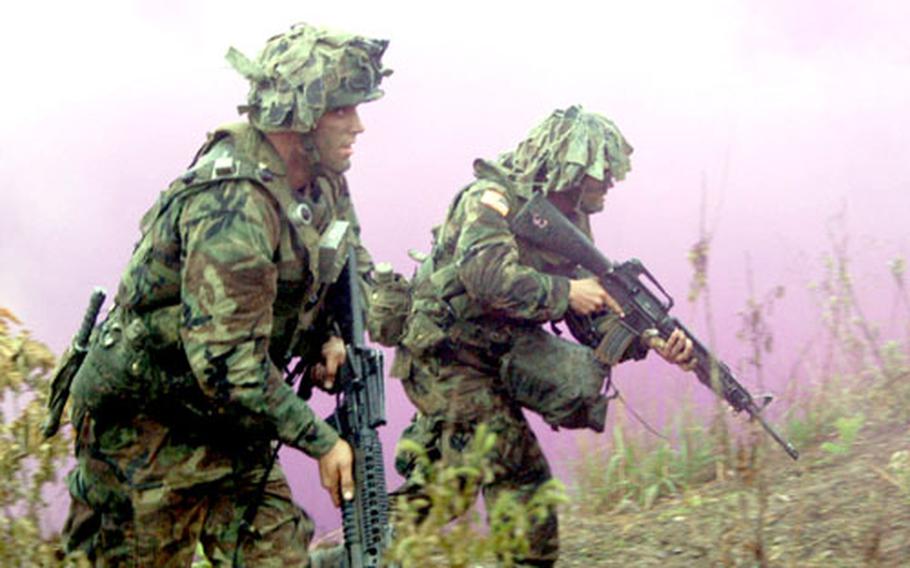 Soldiers from D Company, 2nd Battalion, 9th Infantry Regiment storm up a hillside to take Objective Niner on Rodriguez Range.