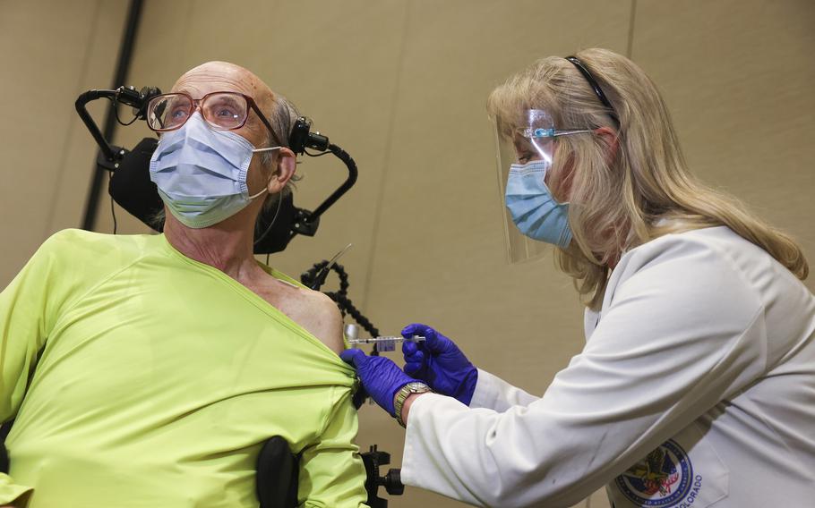 Rocky Mountain Regional VA Medical Center registered nurse Patricia Stamper gives a dose of the Pfizer-BioNTech COVID-19 vaccine to Army veteran Mark Maloney, 85, at the hospital on December 16, 2020 in Aurora, Colo. 