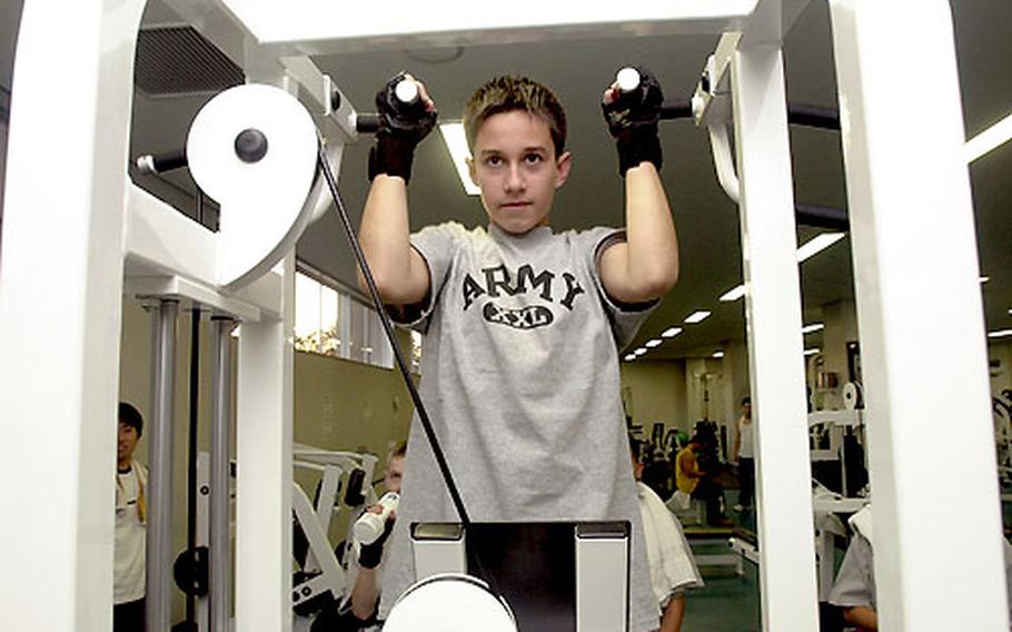 Kevin D’Aversa does a pull-up at the Yano Fitness Center. Trainers give the children advice on weight selection, form and repetitions, and teach them weight-room etiquette.