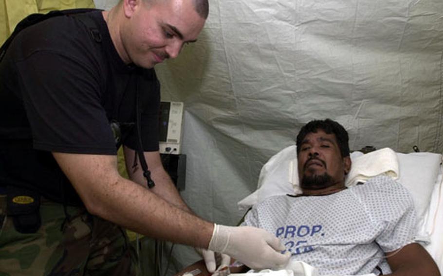 Staff Sgt. Foye Flowers flushes out a patient's IV at the field hospital put up by Yokota's 374th Medical Group outside Guam's only civilian hospital.