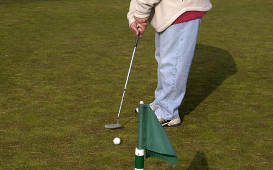 Petty Officer 1st Class Teddy Estella takes advantage of a snow-free landscape to practice his putting technique at the Gosser Memorial golf course at Misawa Air Base, Japan.