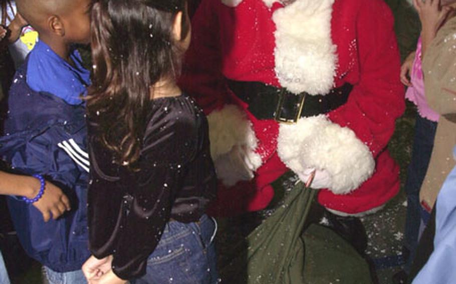 Santa Claus takes a minute to talk to students at Stearley Heights Elementary School on Kadena Air Base, Okinawa, during a stop to pick up cards and letters the students made for deployed servicemembers.