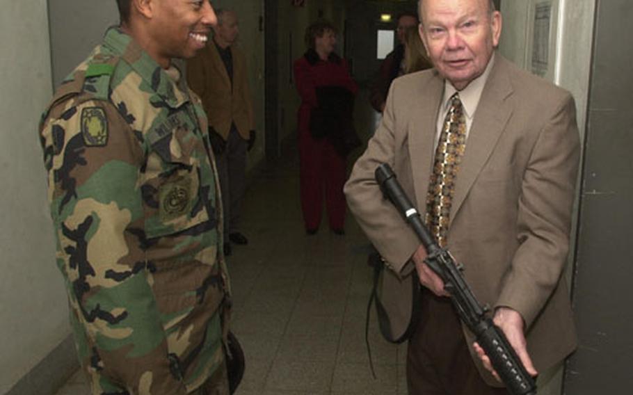 1st Sgt. Gerald Williams, Jr., left, shows an M-4 carbine to retired 1st Sgt. Charles Snow. When Snow joined the Army in 1947, the M-1 Garand was standard issue.