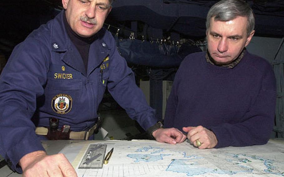Cmdr. Chip Swicker, commanding officer of the USS John S. McCain, shows the route the Aegis-class destroyer takes out of port to Sen. Jack Reed, D-R.I., on board the ship Saturday at Yokosuka Naval Base, Japan. Reed did a swing through South Korea and Japan last week to meet with servicemembers.