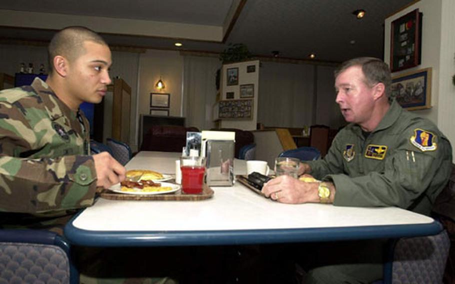 Airman 1st Class Cory Smith, left, listens to Brig. Gen. Dana Atkins discuss the day’s agenda during breakfast Tuesday at the Grissom Dining Hall, Misawa Air Base, Japan.