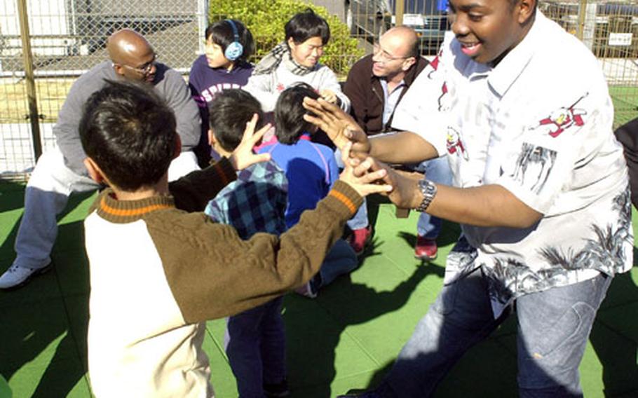 Seaman David John, from the USS Safeguard operating from Sasebo Naval Base, said he had a fantastic time Sunday afternoon playing on a base playground with visiting Japanese orphans. "This is what the holiday season is all about," said John. "It's about the kids."