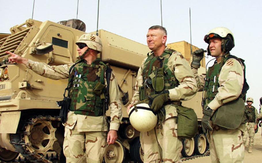From left, 3rd Infantry Division Operations Officer Lt. Col. Peter Bayer, division commander Maj. Gen. Buford "Buff" Blount and Capt. Erik Berdy, the general's aide, stand next to the Army's new command-and-control vehicle as they watch exercises in the Kuwait desert. The new vehicle allows the commander to keep pace with battle leaders in a fight.
