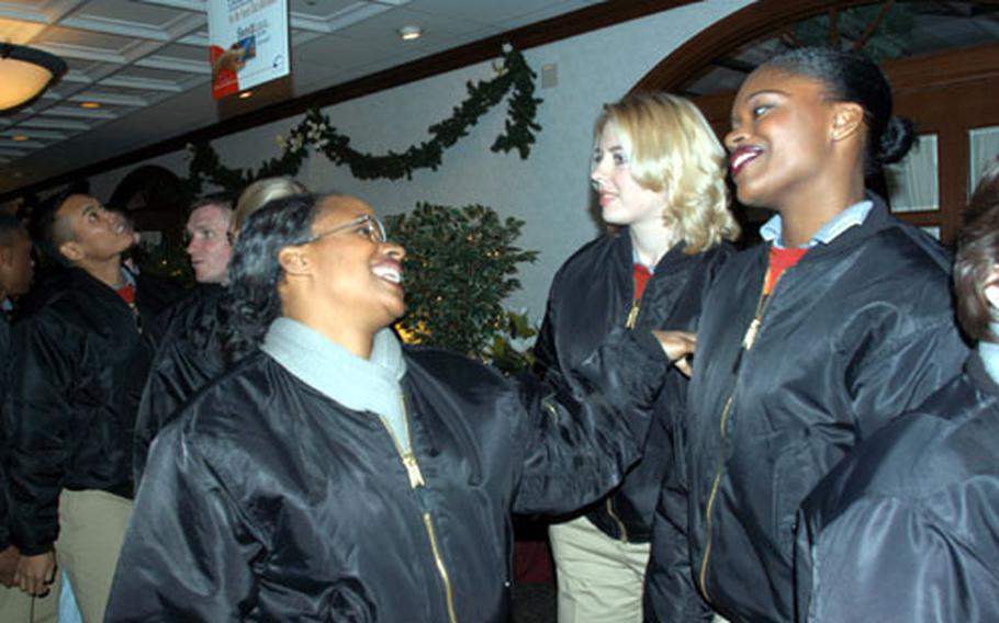 Staff Sgt Evelyn Bruce (left) and Senior Airman Tonie Dickerson share a laugh Saturday night at Yokota Air Base's Officers' Club, after a social during which the Tops in Blue troupe met base officials. The group puts on more than 100 shows a year across the globe.