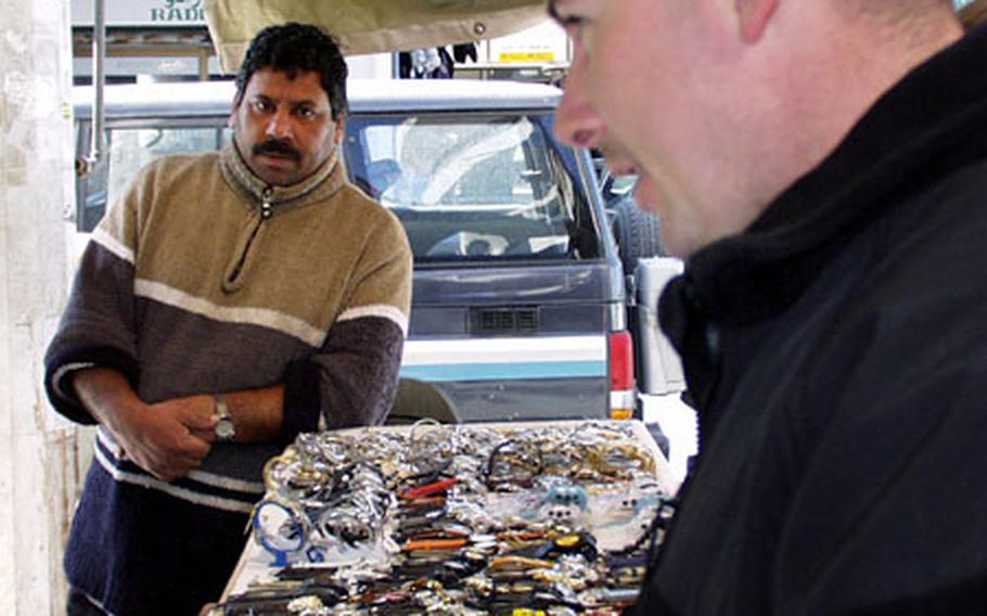 Marine Cpl. David Atencio buys some DVD movies at Kuwait City's souk, a bazaar in the city center.